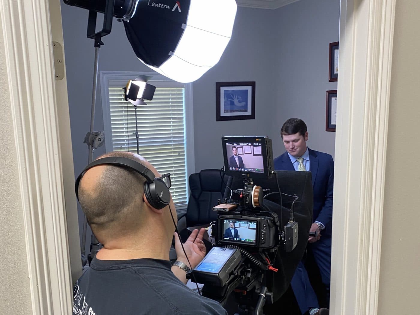 A camera operator filming a Tadda Law Firm attorney seated in an office at the firm