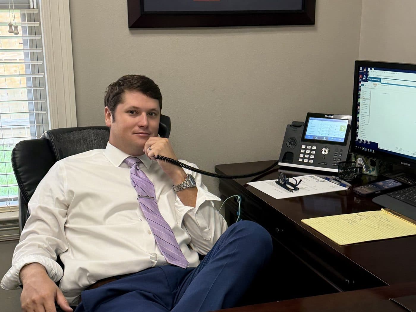 Baton Rouge car accident attorney Rick Tadda on a phone call at his desk in the firm’s office