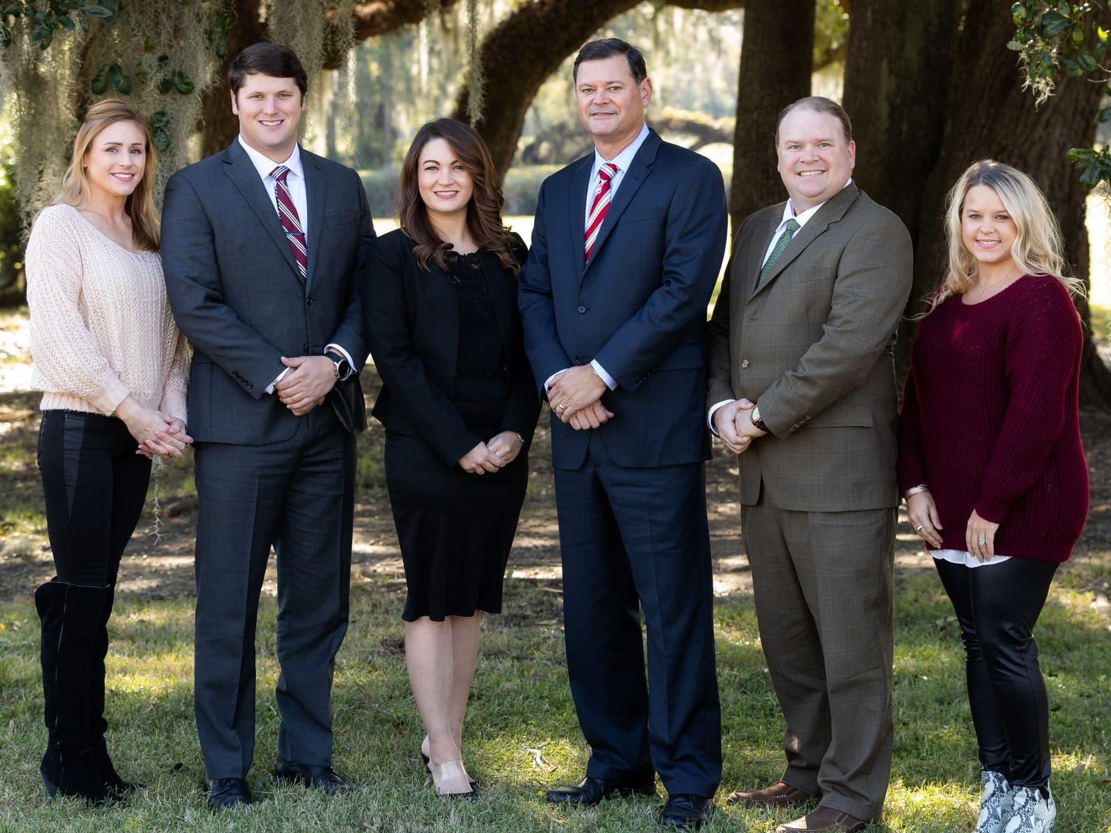 The attorneys and staff of The Tadda Law Firm standing together under a live oak draped in Spanish moss